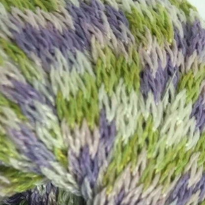 Close-up of green and purple yarn with a control panel in the background