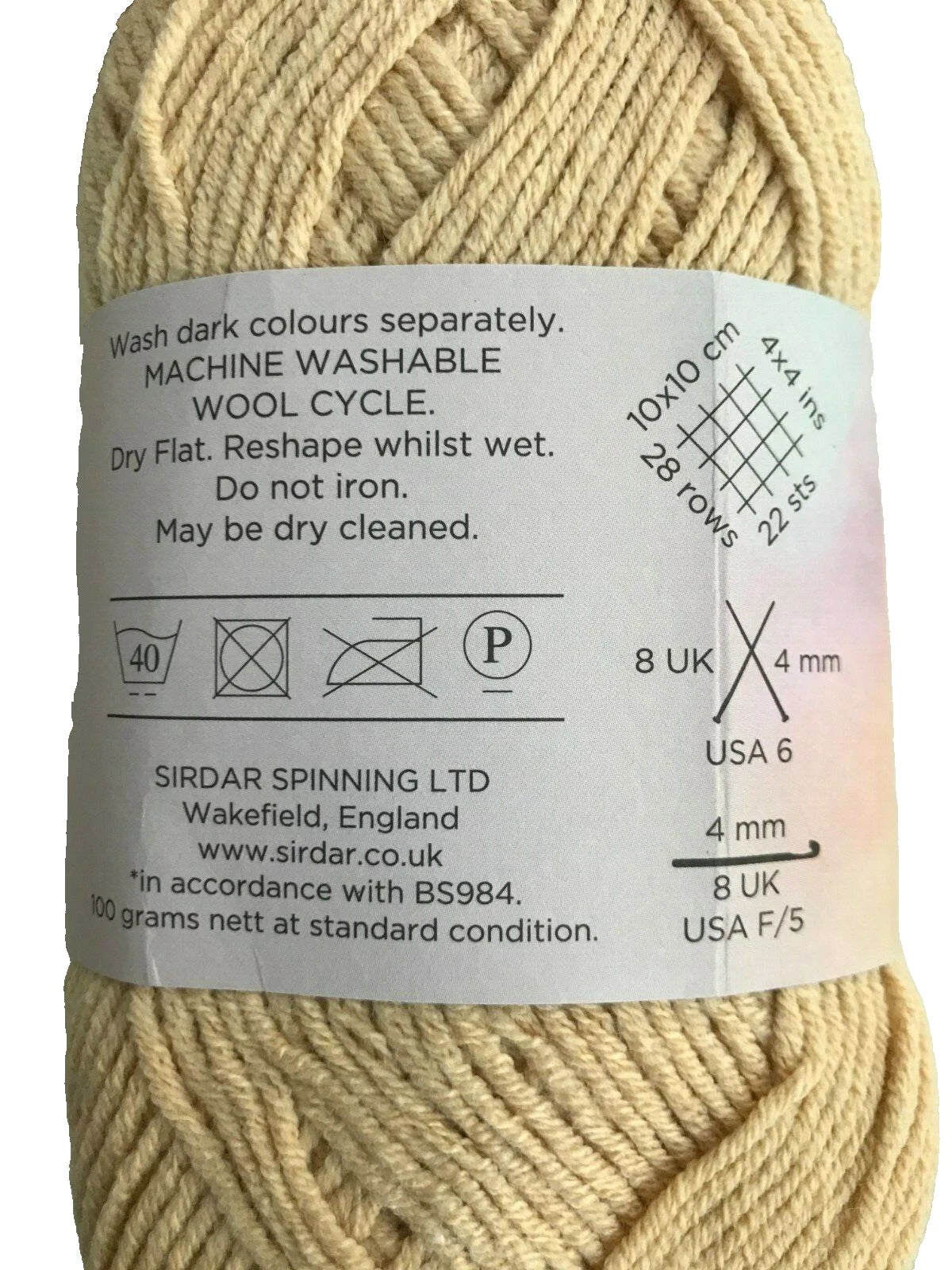 Ball of yarn with label showing washing instructions and size information.
