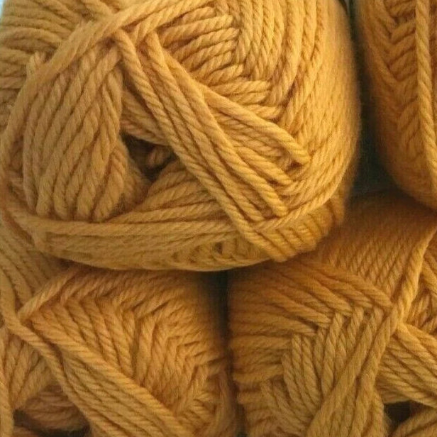 Five balls of mustard yellow yarn stacked on a light blue background