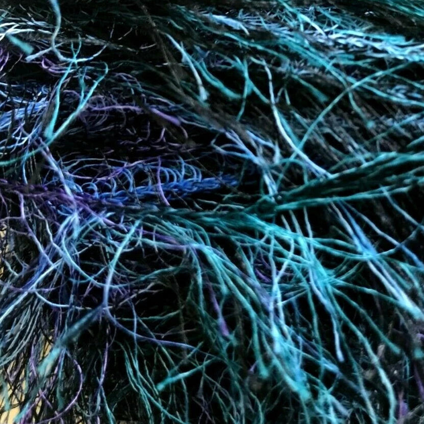 Close-up of a skein of yarn with blue and purple fibers.