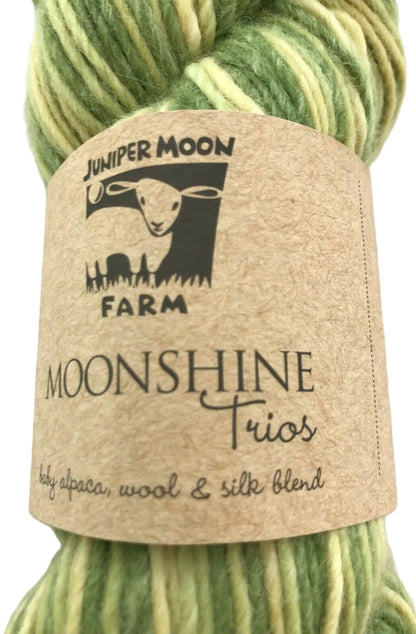 Green yarn skein with 'Juniper Moon Farm Moonshine Trios' label on a light background