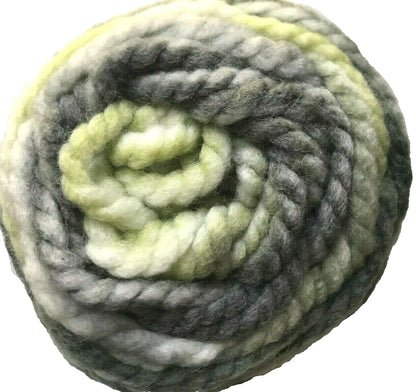 Coiled ball of green and gray yarn on a white background