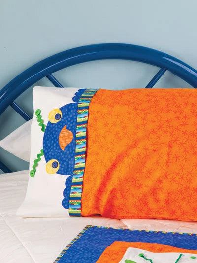 Children's pillow with fish design and orange blanket on a blue chair