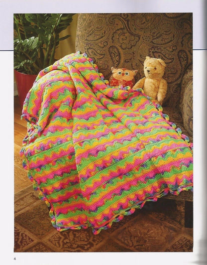 Colorful knitted blanket draped over a chair with two stuffed animals.