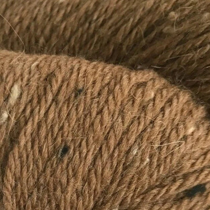 Brown yarn skein with a label on a white background