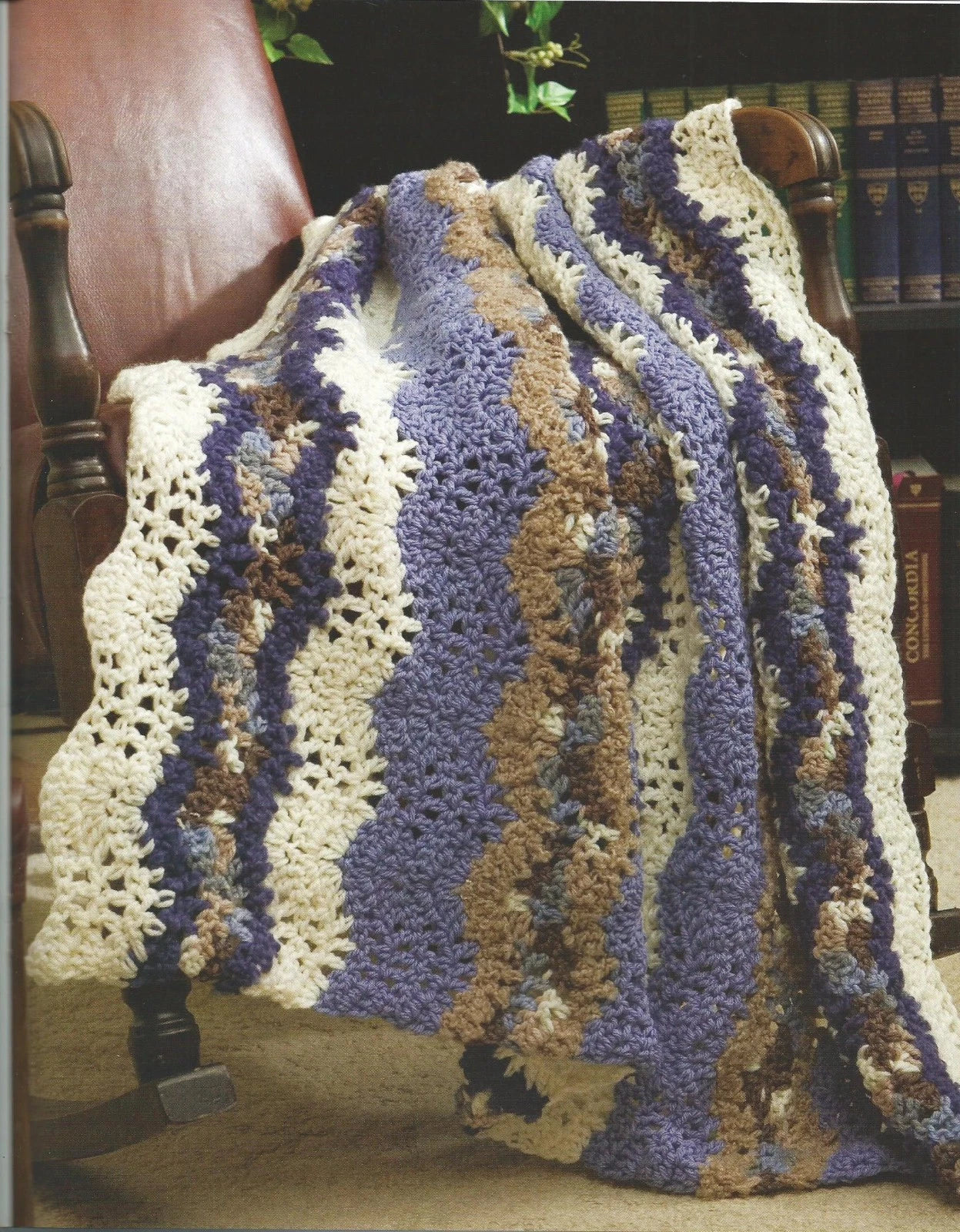 Crocheted blanket with wavy pattern draped over a chair in a home setting.