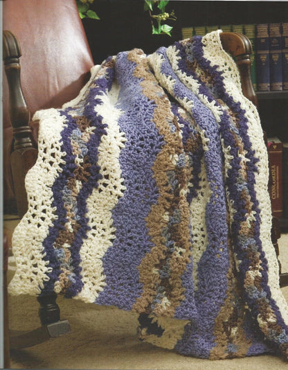 Crocheted blanket with wavy pattern draped over a chair in a home setting.