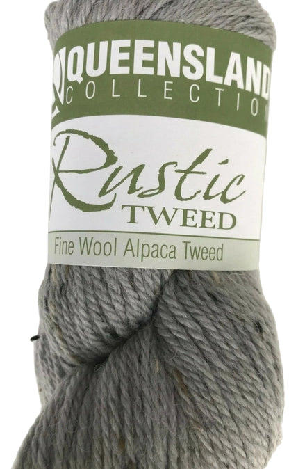 Gray skein of yarn with a label indicating 'Queensland Collection Rustic Tweed' on a white background.