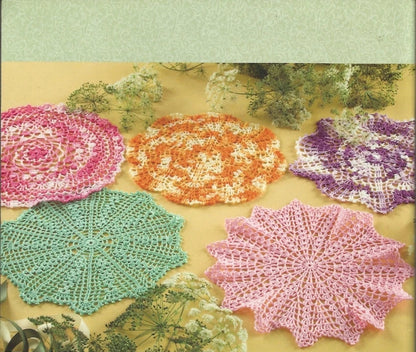 Yarn pattern book cover with crocheted doilies in various colors on a green background