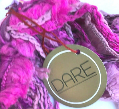 Pink yarn with a 'DARE' tag in the foreground