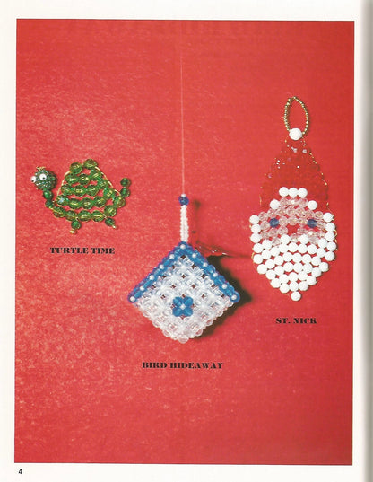 Three beaded Christmas ornaments labeled 'Tumble Time', 'Bird Hideaway', and 'St. Nick' on a red background.