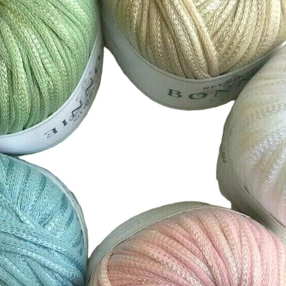 Close-up of various balls of yarn in pastel colors with brand labels.