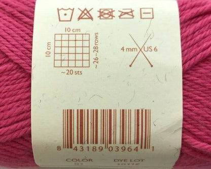 Close-up of a label on a ball of pink yarn with measurement and care instructions.
