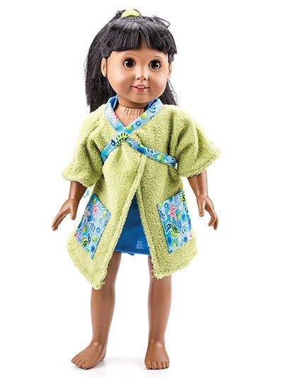 Doll wearing a green outfit with floral patterns on a white background