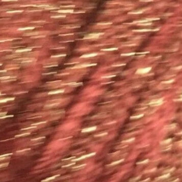 Spool of red yarn with gold glitter on a white background