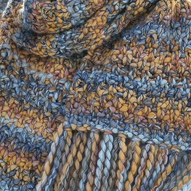 Close-up of multicolored yarn with shades of blue, orange, and brown.