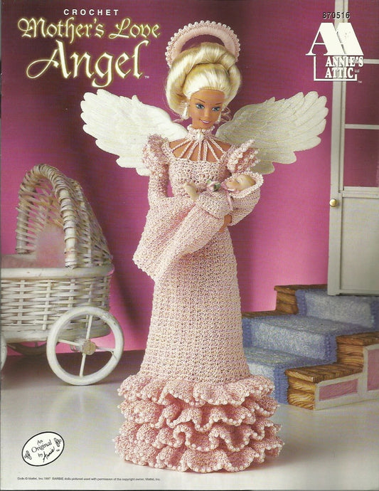 Crocheted angel doll with baby in a pink dress against a pink background, featuring Annie's Attic branding.