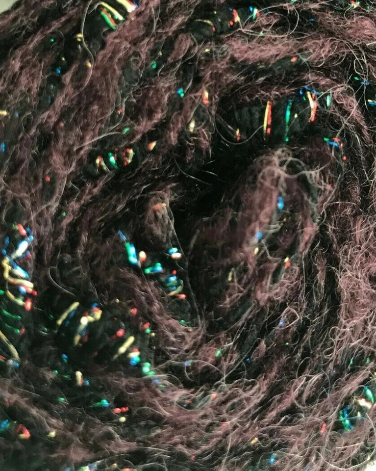Close-up of dark brown yarn with colorful beads