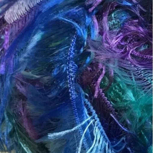 Close-up of colorful yarn with blue, purple, and green hues.