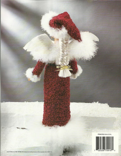 Knitted angel figurine with red robe and white wings on a snowy background