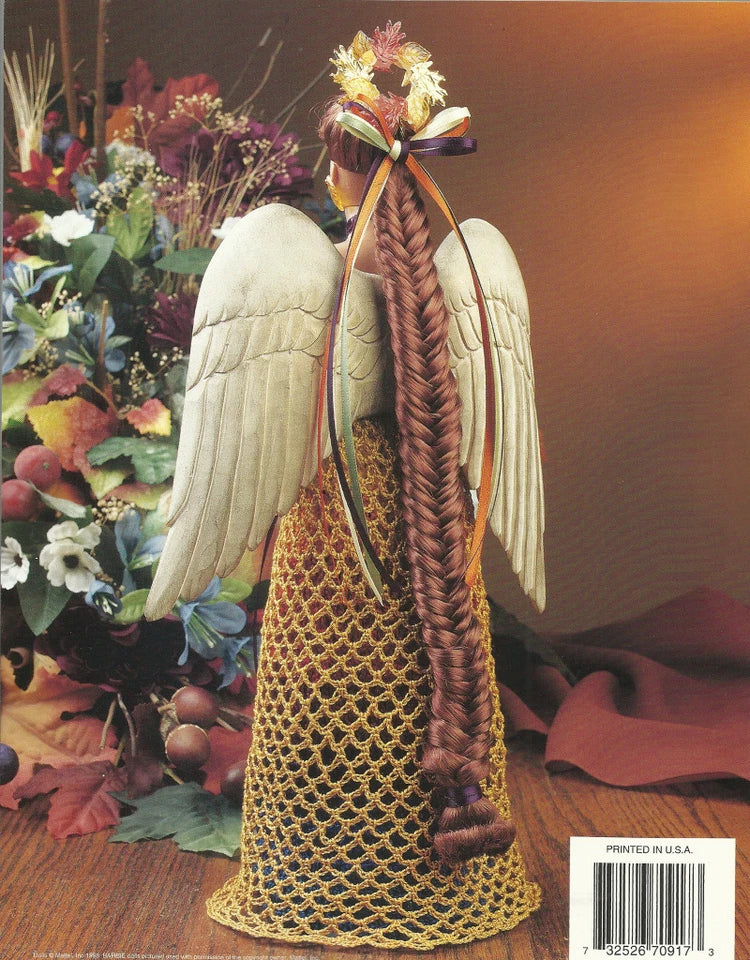 Decorative angel figurine with wings and braided hair, surrounded by flowers on a wooden surface.