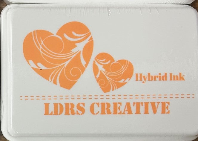 An image of a white ink pad featuring two orange hearts and the text "LDRS CREATIVE Hybrid Ink" in a bright orange color.